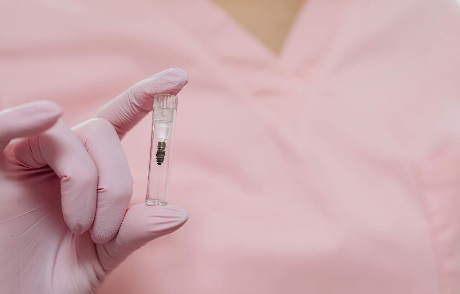 A close-up view of a gloved hand holding a small medical sample vial, focusing on healthcare and medicine.