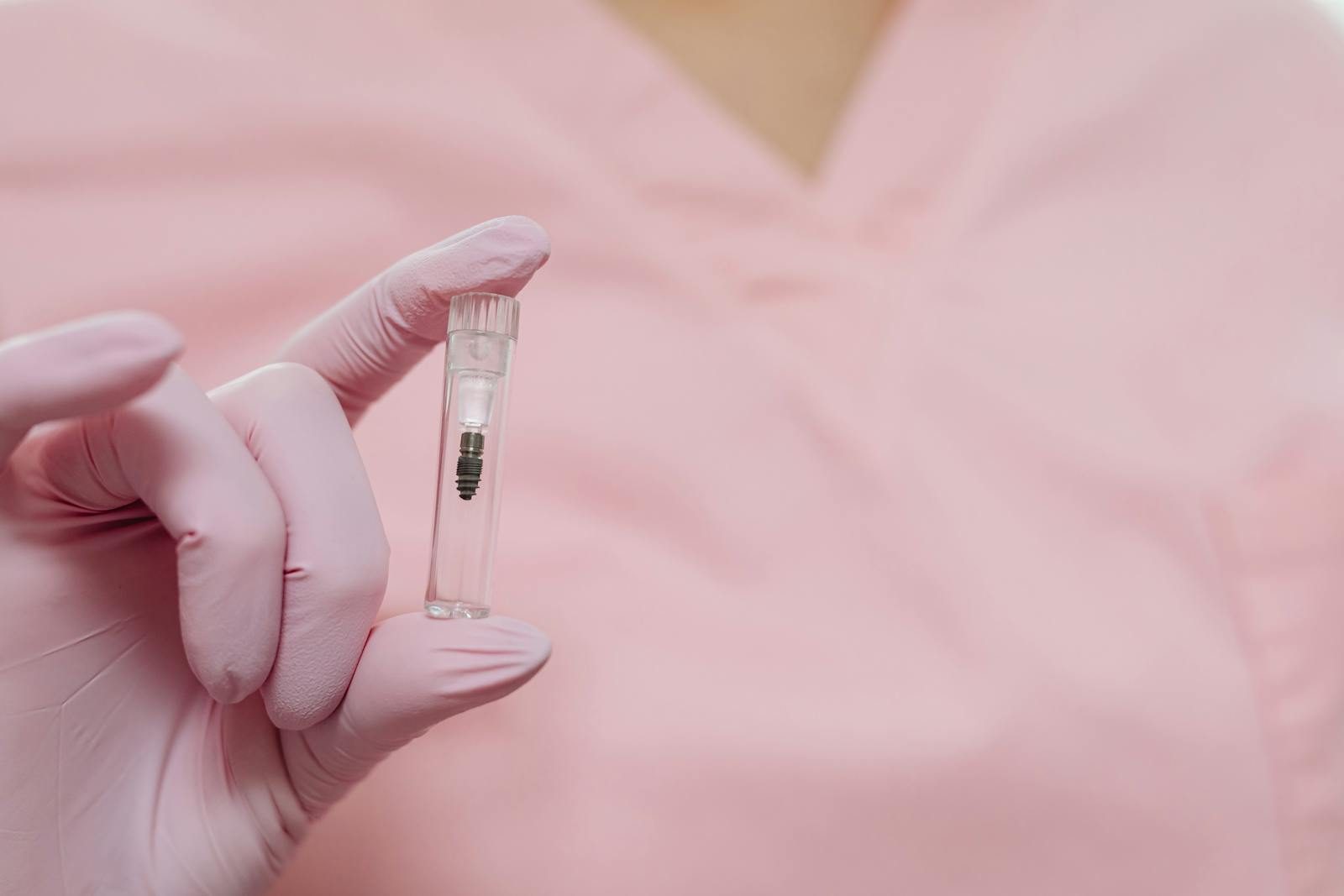 A close-up view of a gloved hand holding a small medical sample vial, focusing on healthcare and medicine.