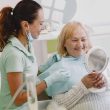 Senior patient at a dental check-up, smiling with the dentist in a modern clinic.