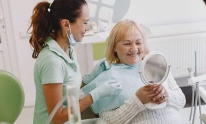 Senior patient at a dental check-up, smiling with the dentist in a modern clinic.