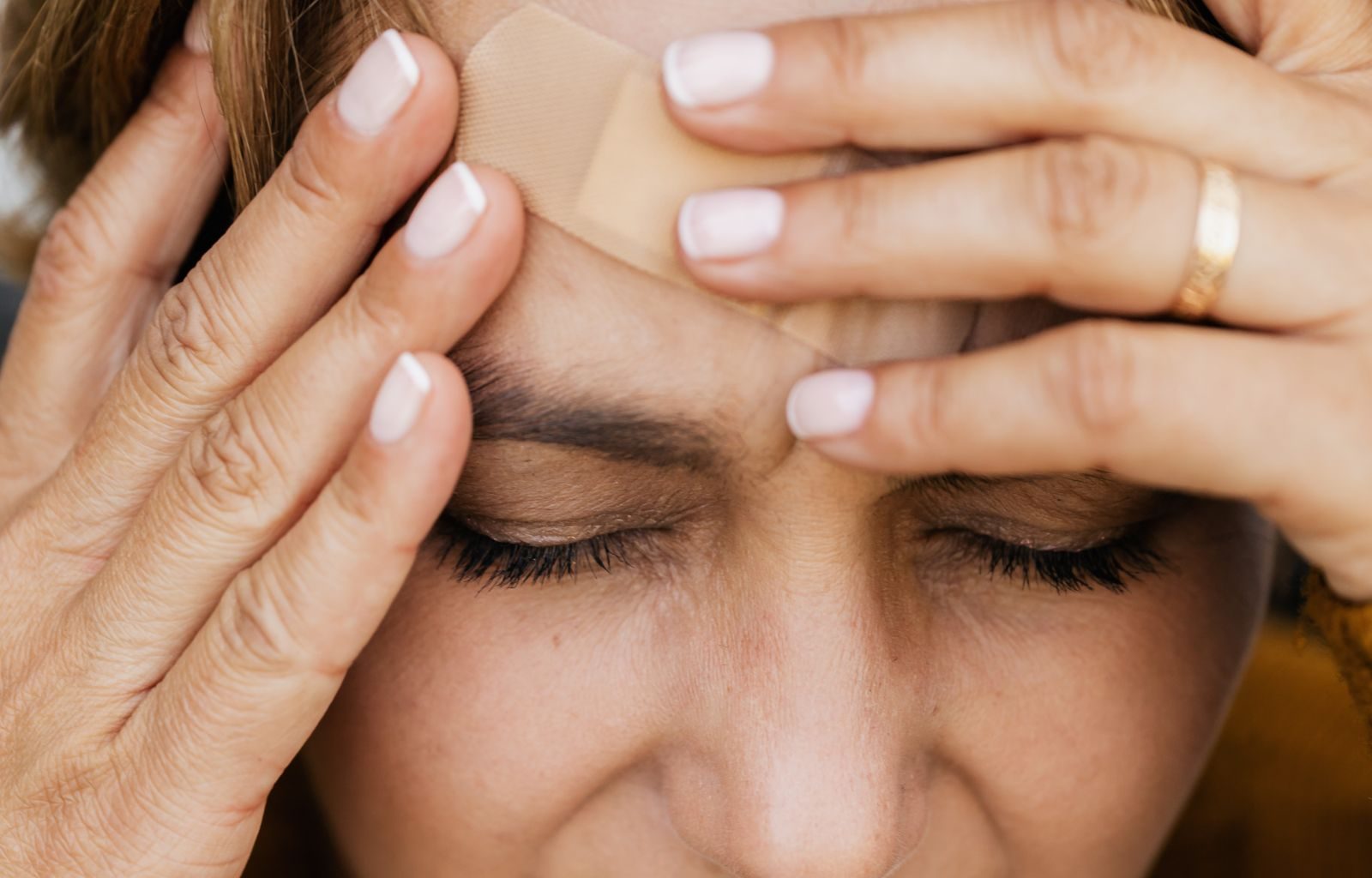 Pessoa com dor na região da face e cabeça, sintoma associado a disfunção temporomandibular